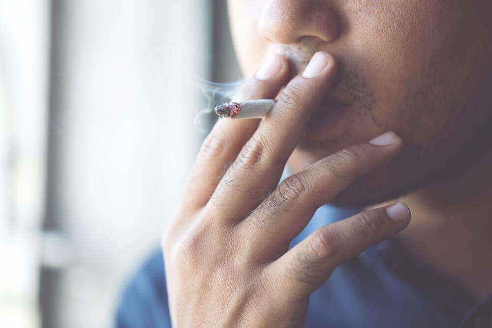 Chico fumando un cigarrillo.