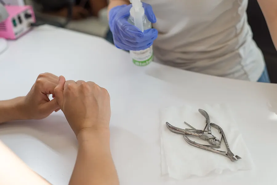 Manicurista desinfectando herramientas