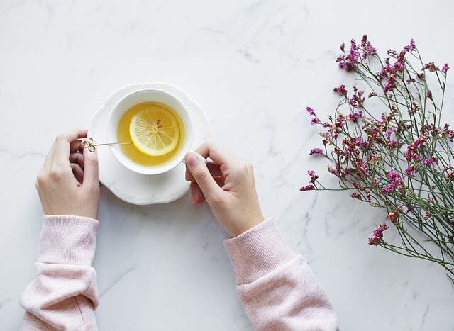 Mujer tomando una infusión de limón.