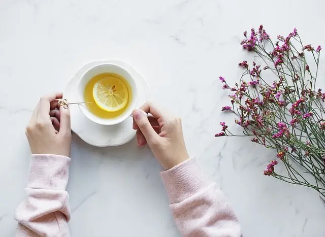 Mujer tomando una infusión de limón.