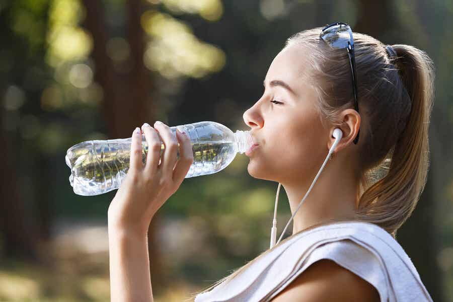Mujer bebiendo agua antes de empezar a hacer deporte