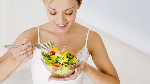 Mulher comendo salada