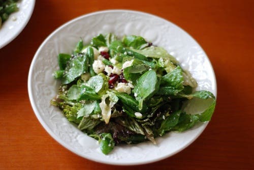Plato de ensalada de canónigos con queso de cabra y semillas de calabaza