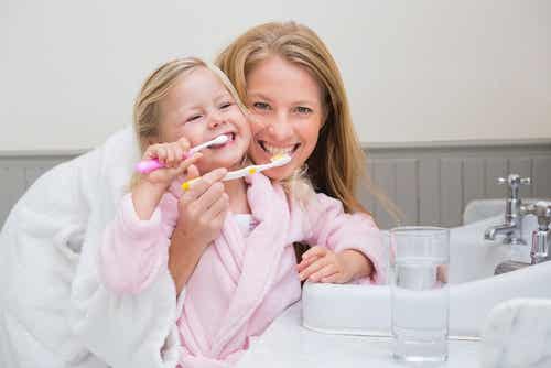 Madre e hija cepillándose los dientes: buena higiene bucal en los niños