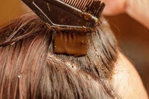 Mujer aplicándose en el cabello tinte de henna