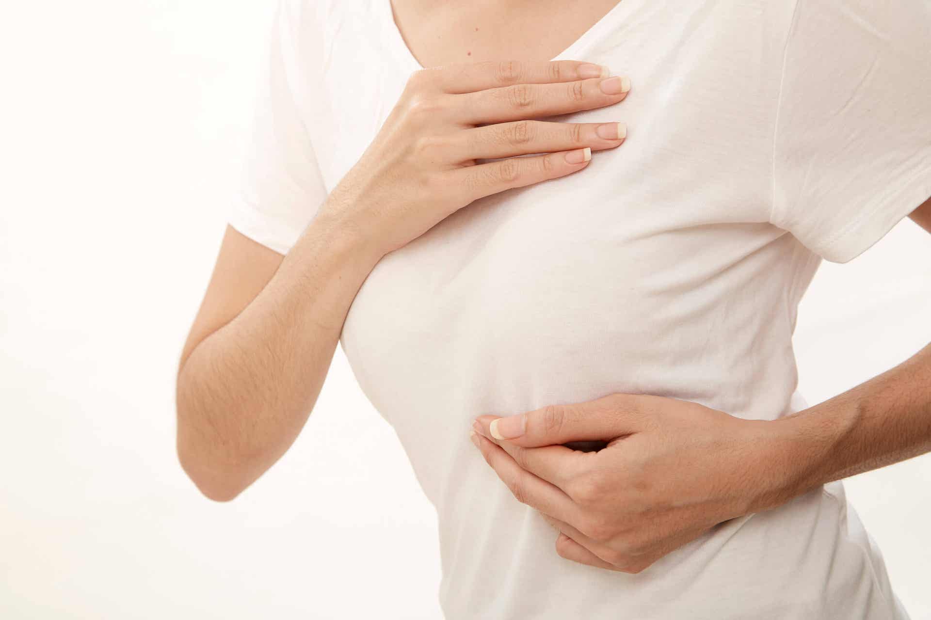Progesteroncreme - Frau fasst sich an die Brust
