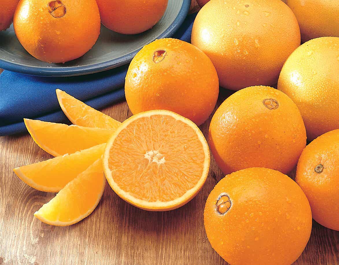 Naranja cortada con naranjas sin cortar