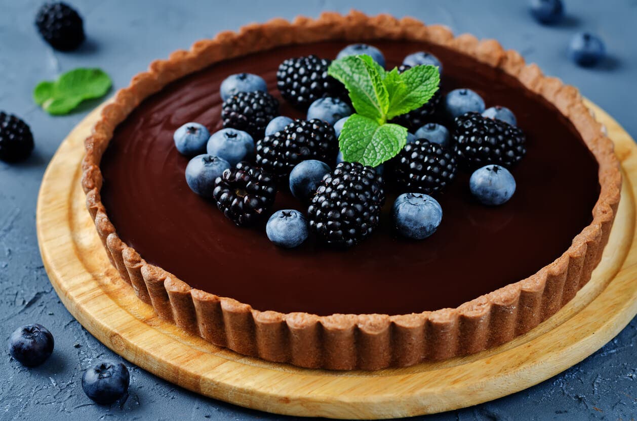 Tarta de crema de chocolate decorada con frutos rojos