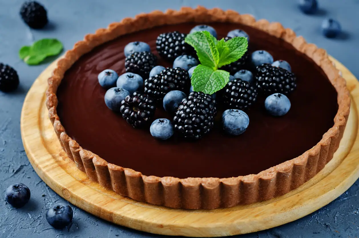 Tarta de crema de chocolate decorada con frutos rojos