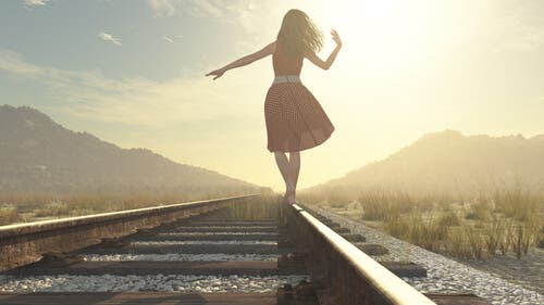 Mujer caminando por una vía