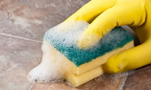 Mujer limpiando superficie con guantes