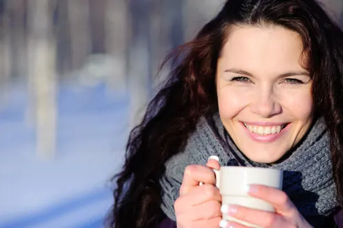 Mujer tomando una infusión para combatir el frío en las manos