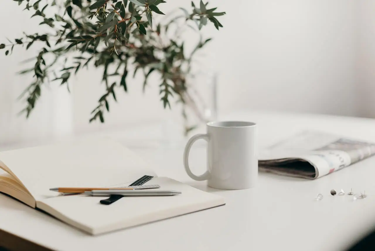 21-Tage-Plan - Papier, Stifte, eine Tasse und eine Zeitung