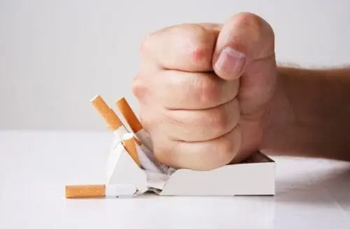 Person ødelægger en pakke cigaretter