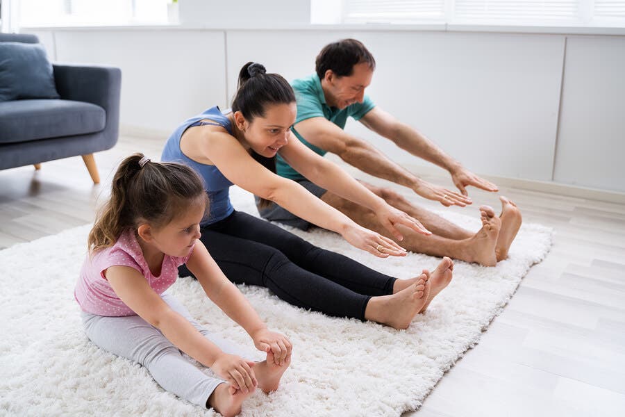 Familia haciendo estiramientos en casa.