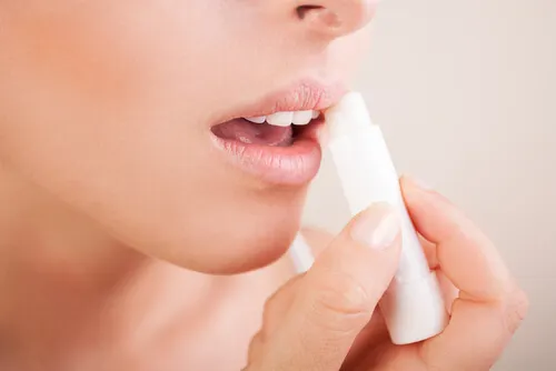 Mujer aplicándose protector labial.