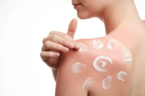 mujer aplicándose protector solar