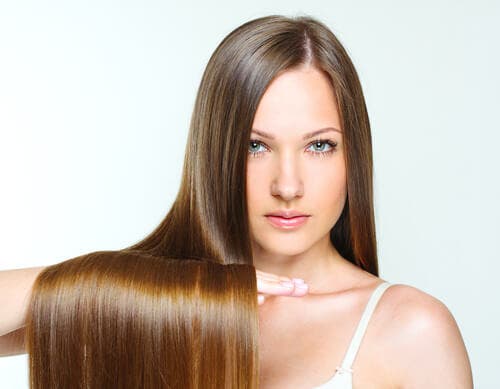 Mujer con pelo lacio largo y brillante gracias a la mascarilla natural que se ha aplicado