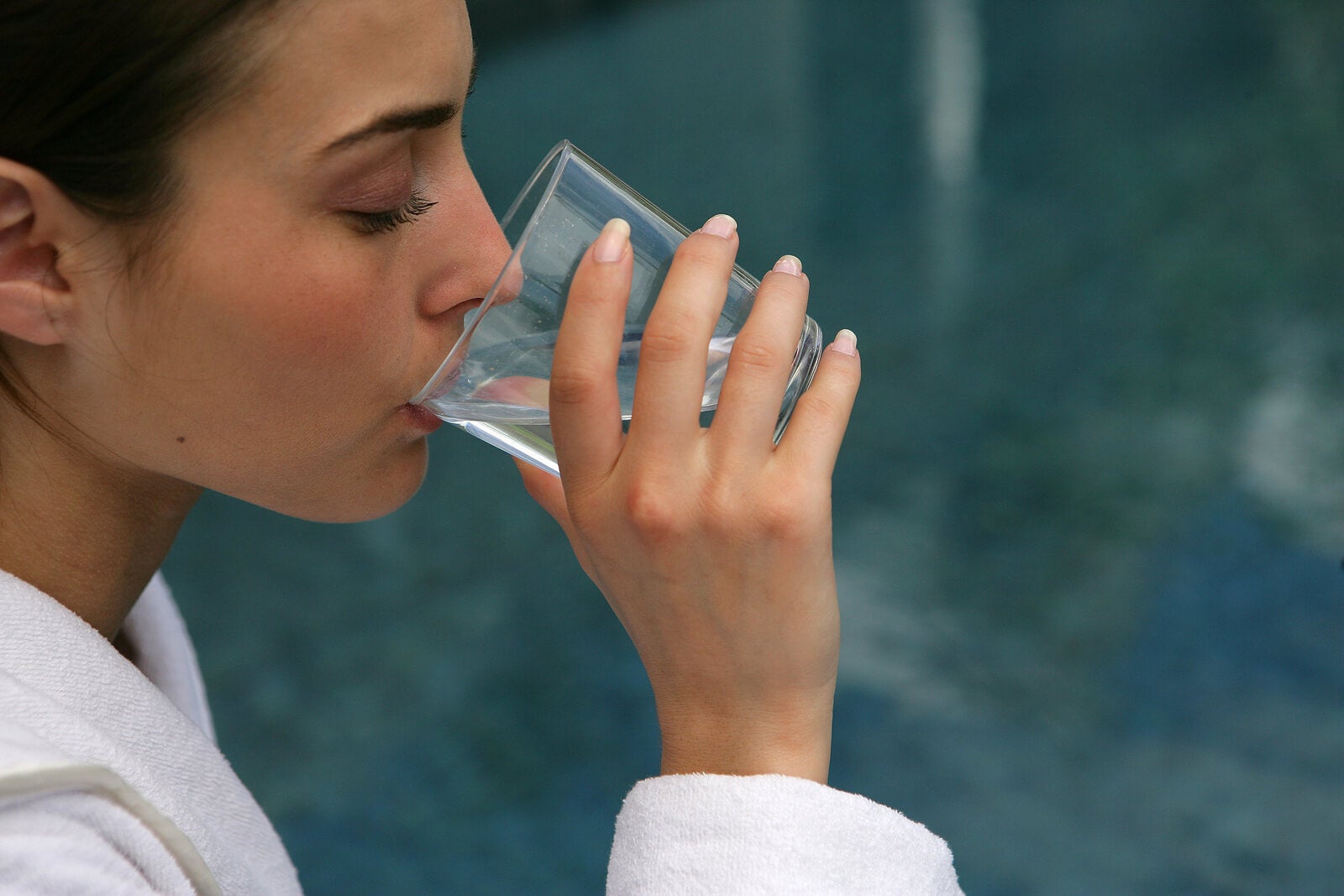 Mulher bebe água com bicarbonato de sódio.