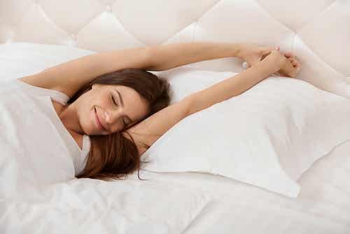 Mujer despertándose contenta en la cama