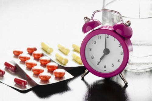 Different medications beside a clock.