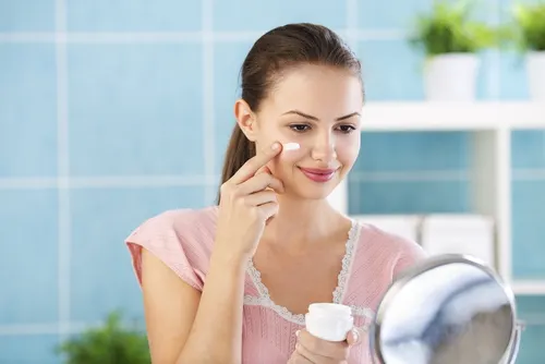 Mujer echándose crema en el rostro