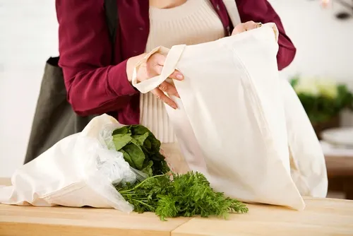 Mujer sacando la compra de una bolsa de tela