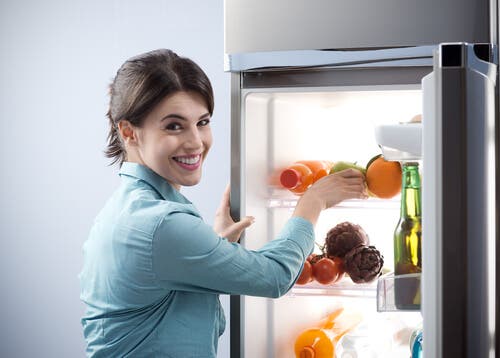 mujer guardando alimentos en la nevera