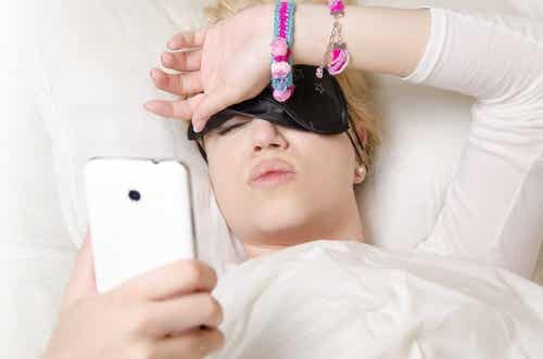 mujer en la cama mirando el móvil