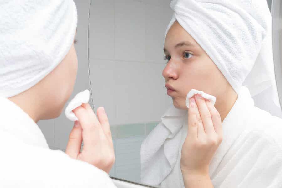 Mujer limpia su piel con acné