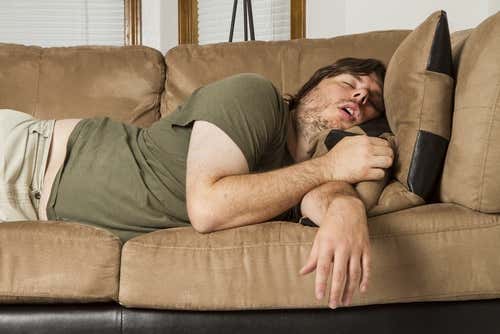 Mand på sofa sover i stilling, der kan forårsage, at hans hænder sover
