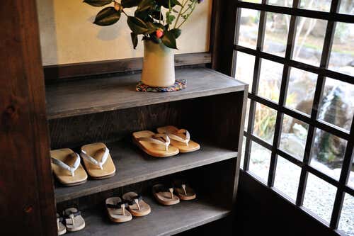 Zapatos en un estante a la entrada de la casa