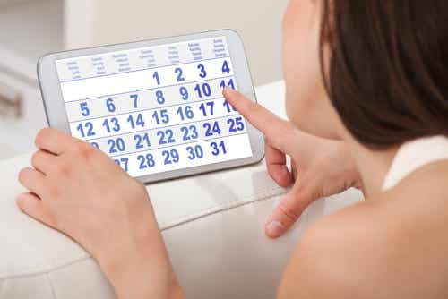 Mujer con un calendario calculando el periodo menstrual