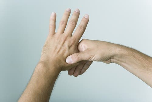 Mano cogiendo el pulgar de la otra mano