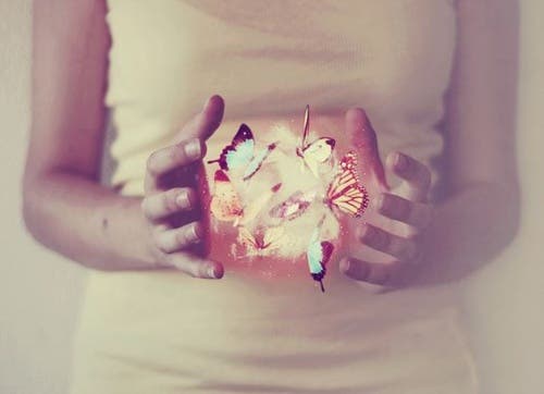 Mujer con mariposas en la mano simbolizando desapego