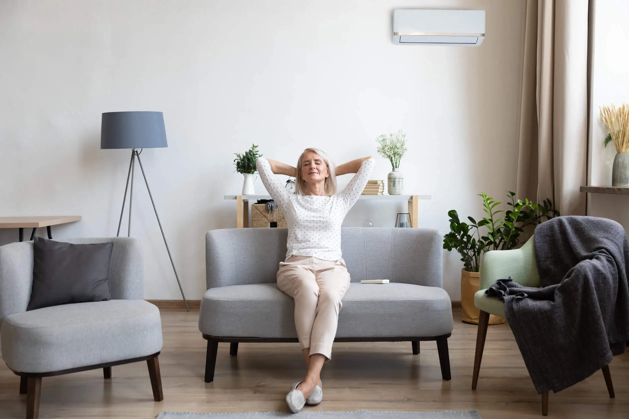 Mujer en una sala con sofá.