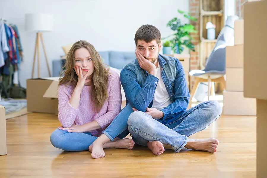 Pareja sentada en el suelo pensando.
