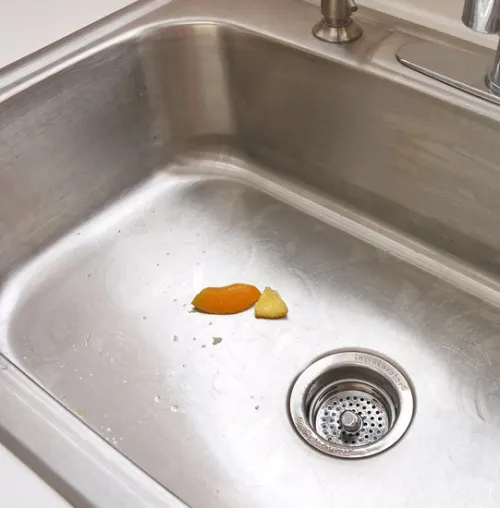Trozo de naranja en un fregadero metálico
