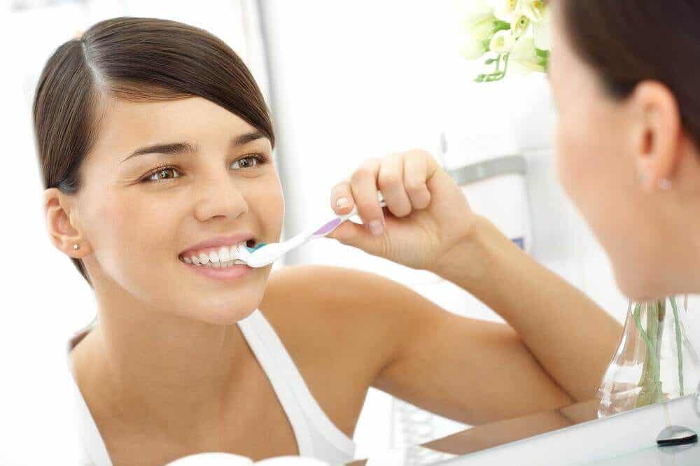 Cepillar los dientes para cuidar la salud oral.