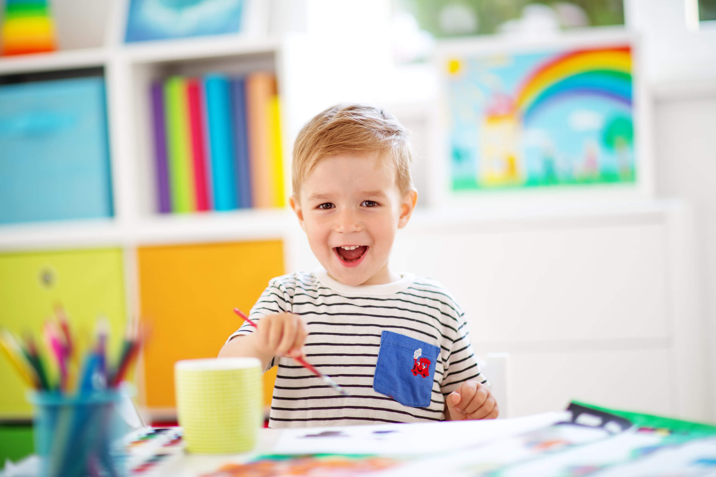 Bambino con colori e pennello.