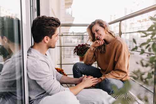 ufak bir balkonda yere oturmuş sohbet eden kadın ve erkek