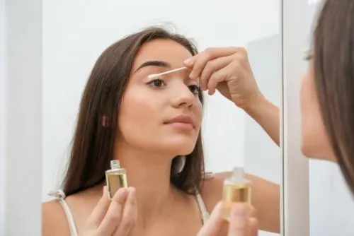 Mujer limpiándose las pestañas con aceites