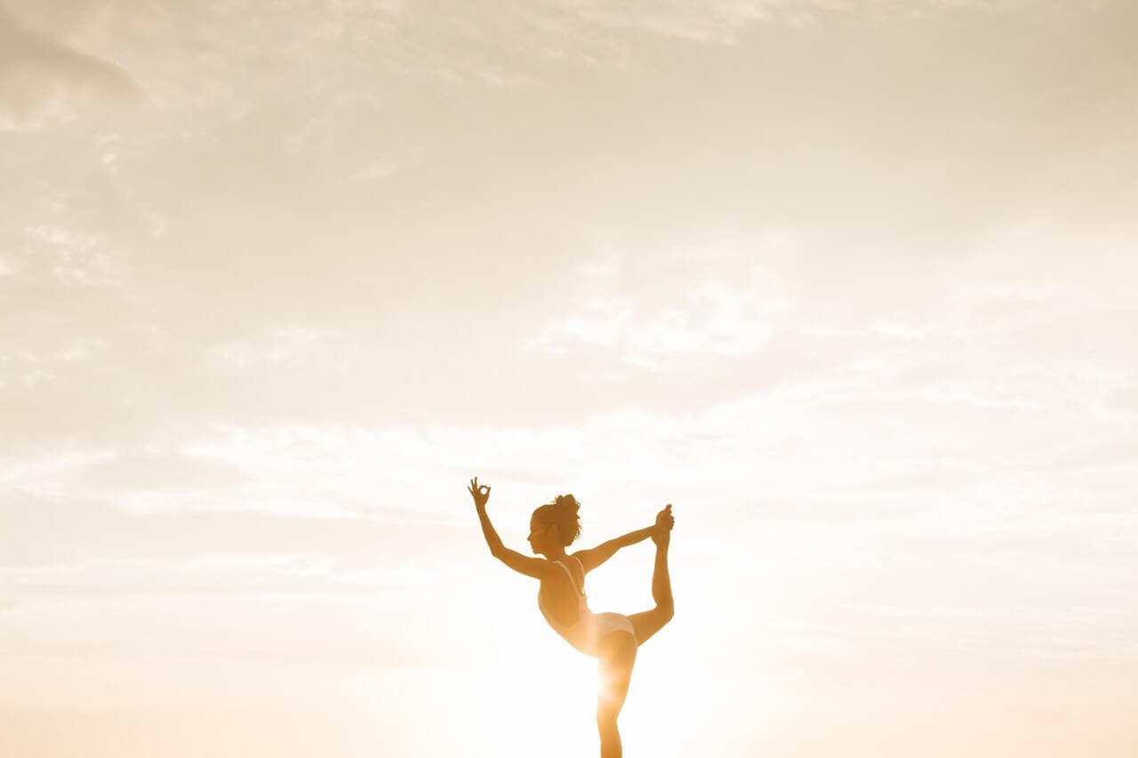 Mujer haciendo yoga para obtener sus beneficios emocionales.