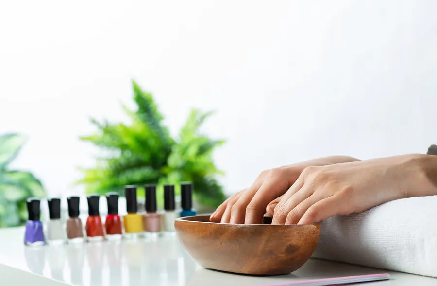 Manos con agua fría para secar rápido la pintura de uñas.