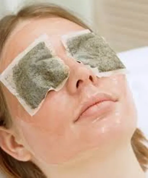 Mujer con bolsas de manzanilla en los ojos.