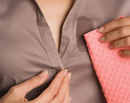 Mujer limpiándose la camisa