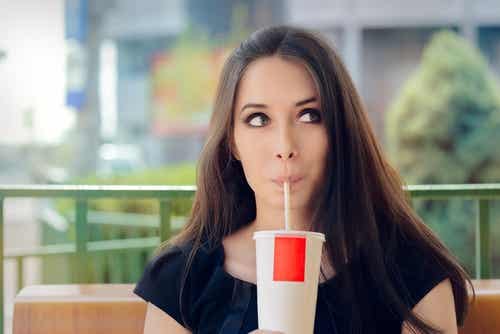 Woman drinking a soda to illustarte decisions that could increase our biological age