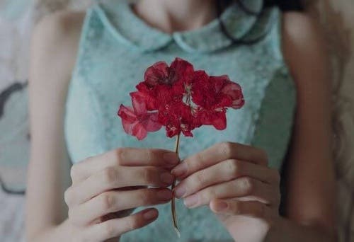 Mujer con una flor rosa