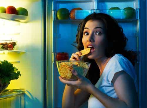 Kvinde går i køleskabet efter kiks om aftenen
