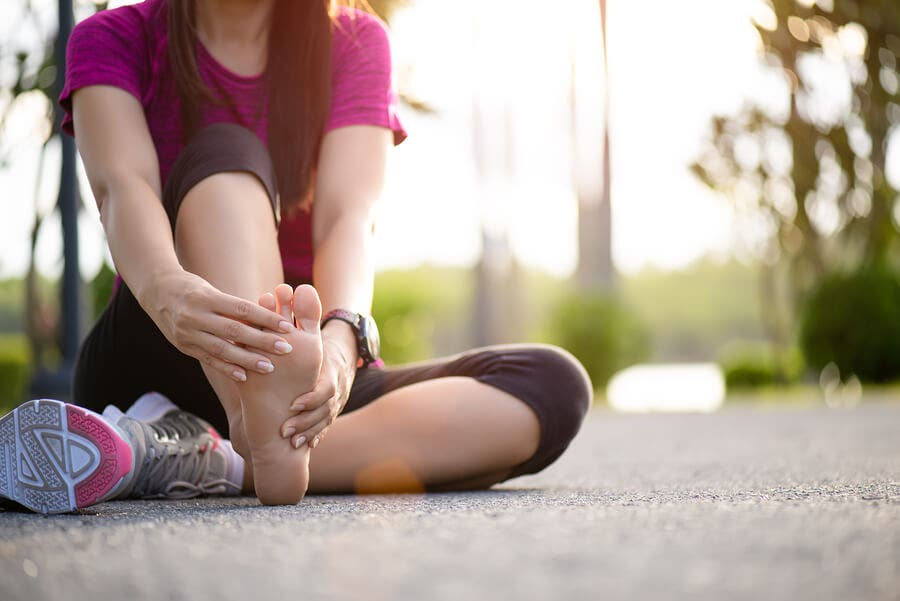 Mujer con un calambre en la pierna por correr sin calentar.